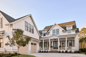 White coastal-style townhouse row with gabled roofs and a covered porch.